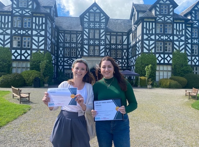 Holding certificate in front of a villa